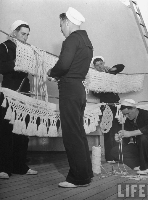 Navy crew knotting macramé garlands on deck